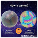 Reflective night training soccer ball positioned for power shot under park street lamps with glowing panels