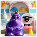King Amoeba Mutant making funny faces with sheep toilet paper holder in colorful kids bathroom - TKT mascot